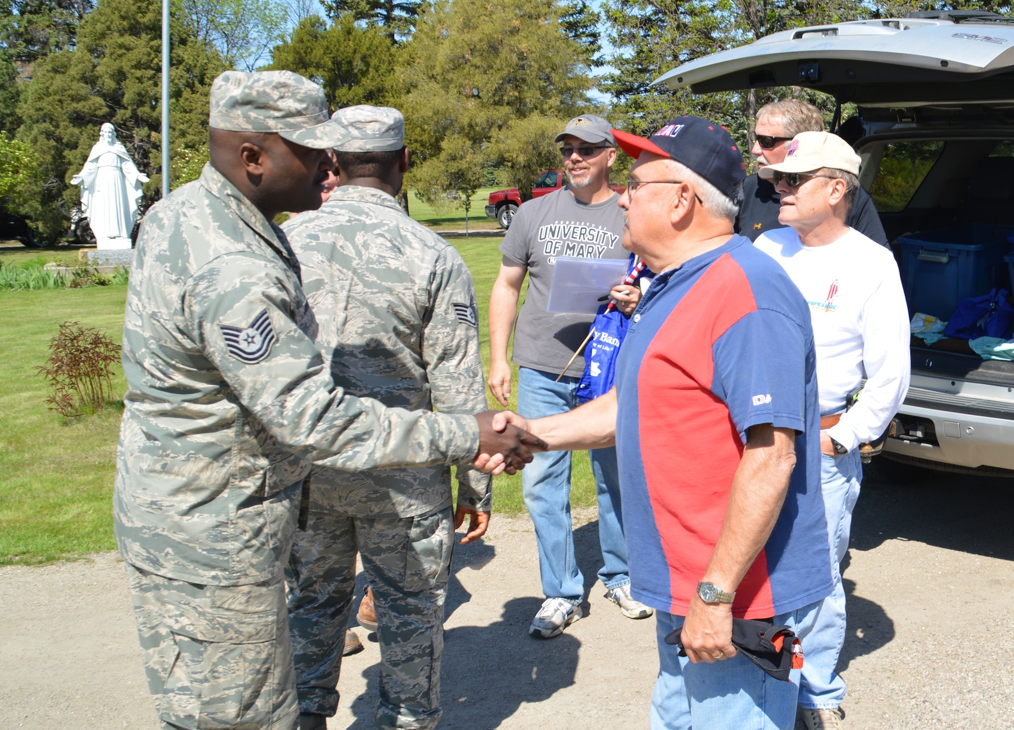 Members of the Disabled Veterans of America, Andy Nomland Chapter 2 of Grand Forks, N.D., take a moment to thank active-duty members from Grand Forks Air Force Base, N.D., for helping place small U.S. flags on the gravesites of U.S. military veterans May 22, 2015, at Memorial Park South Cemetery located by South Washington Street in the city of Grand Forks. More than 150 Airmen volunteered. The Warriors of the North were asked to wear their Airman Battle Dress Uniform in observance of Memorial Day. (U.S. Air Force photo/Staff Sgt. Luis Loza Gutierrez)