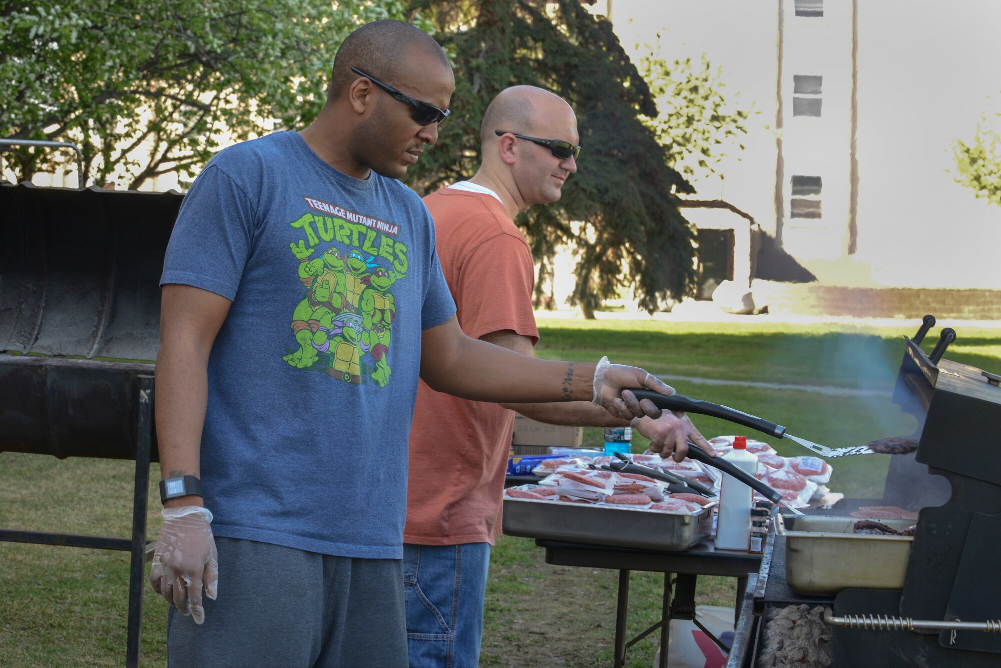 U.S. Air Force Staff Sgt. Chanson Johnson, a 354th Security Forces Squadron combat arms instructor, cooks burgers with Tech. Sgt. Brian Brown, the 354th Civil Engineer Squadron Prime BEEF manager, during the wing Resilient Airman Day May 21, 2015, at Eielson Air Force Base, Alaska. Volunteers cooked more than 400 hotdogs and hamburgers for Airmen. (U.S. Air Force photo by Senior Airman Ashley Nicole Taylor/Released)