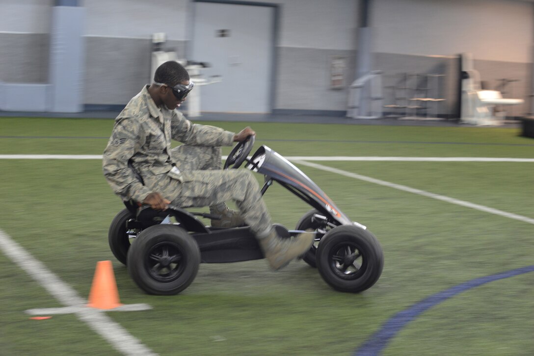 U.S. Air Force Senior Airman Avery Reeves, a 354th Logistics Readiness Squadron vehicle maintainer, concentrates on avoiding a cone during the Alcohol Awareness and Safety Expo May 21, 2015, at the Baker Field House on Eielson Air Force Base, Alaska. Airmen attended the expo to demonstrate pitfalls of poor decision making. (U.S. Air Force photo by Senior Airman Ashley Nicole Taylor/Released)