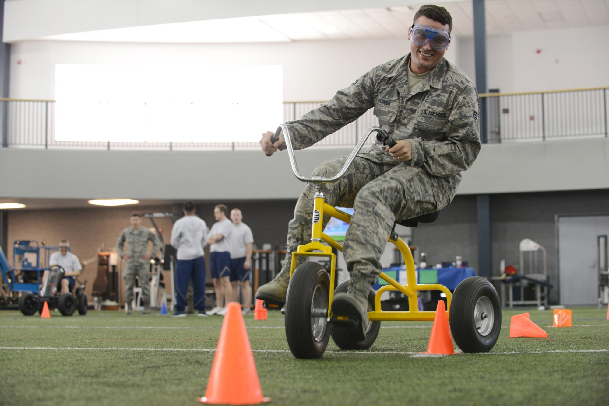 U.S. Air Force Senior Airman Josh Weaver, a 354th Fighter Wing public affairs broadcaster, knocks down a cone while wearing drunk goggles during the Alcohol Awareness and Safety Expo May 21, 2015, at the Baker Field House on Eielson Air Force Base, Alaska. Airmen received a first-hand experience of wearing the drunk goggles while driving a tricycle, demonstrating how much coordination depends on vision. (U.S. Air Force photo by Senior Airman Ashley Nicole Taylor/Released)