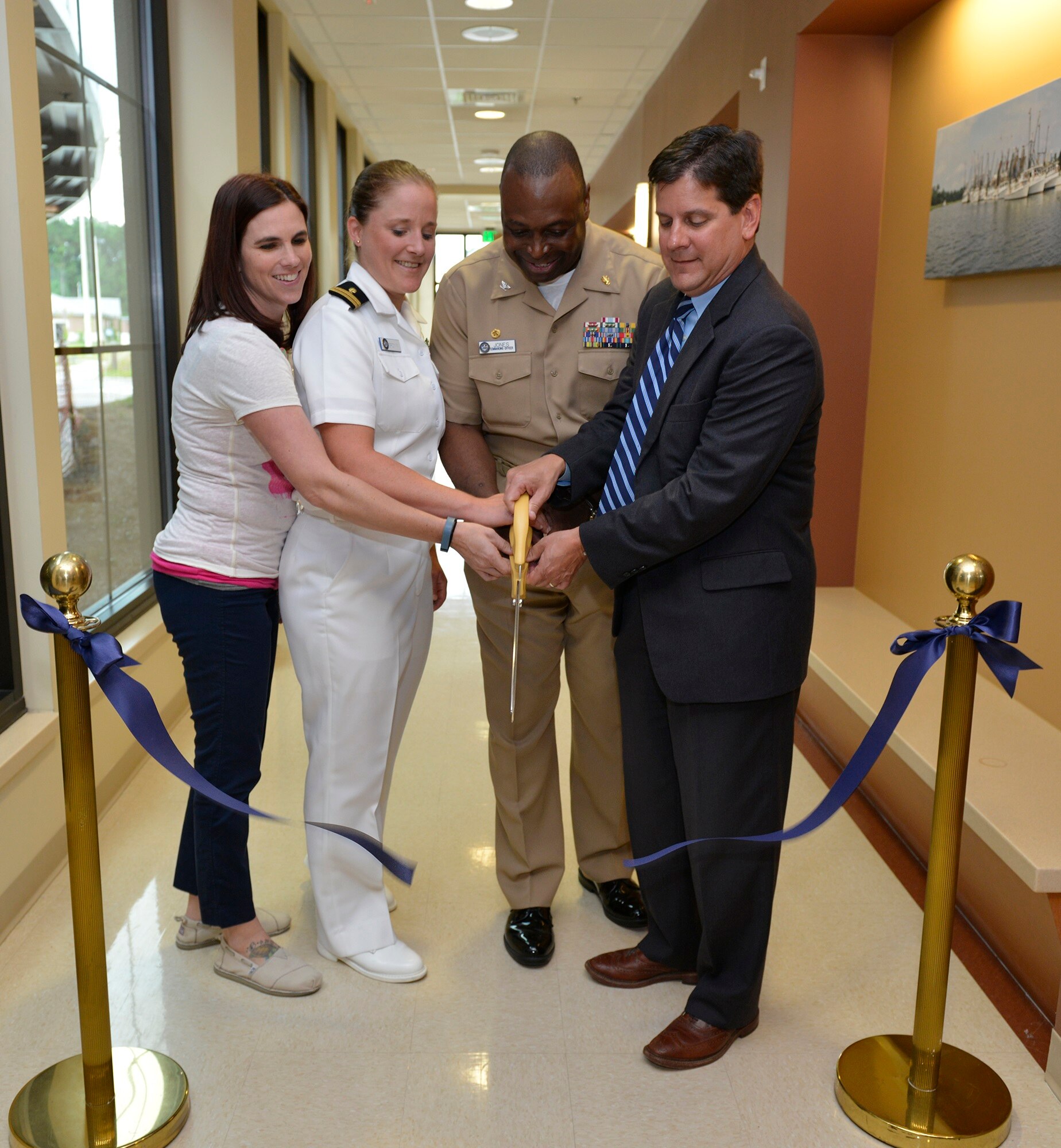 Lori Merrow, VA physical therapist; Navy Lt. Lauren Brown, Department of Defense physical therapist;  Navy Capt. Marvin Jones, commanding officer of Naval Health Clinic Charleston; and Scott Isaacks, director of the Ralph H. Johnson VA Medical Center, cut the ribbon to officially open the joint VA-DoD Physical Therapy Clinic during a ceremony May 20, 2015 at the NHCC at Joint Base Charleston, S.C. The clinic is part of the Lowcountry Federal Healthcare Alliance, which is designated as a Joint Venture site and recognized by both the Department of Defense and the Department of Veterans Affairs for collaboration efforts to improve medical services for beneficiaries of both agencies. (Courtesy photo / Ralph H. Johnson VA Medical Center)
