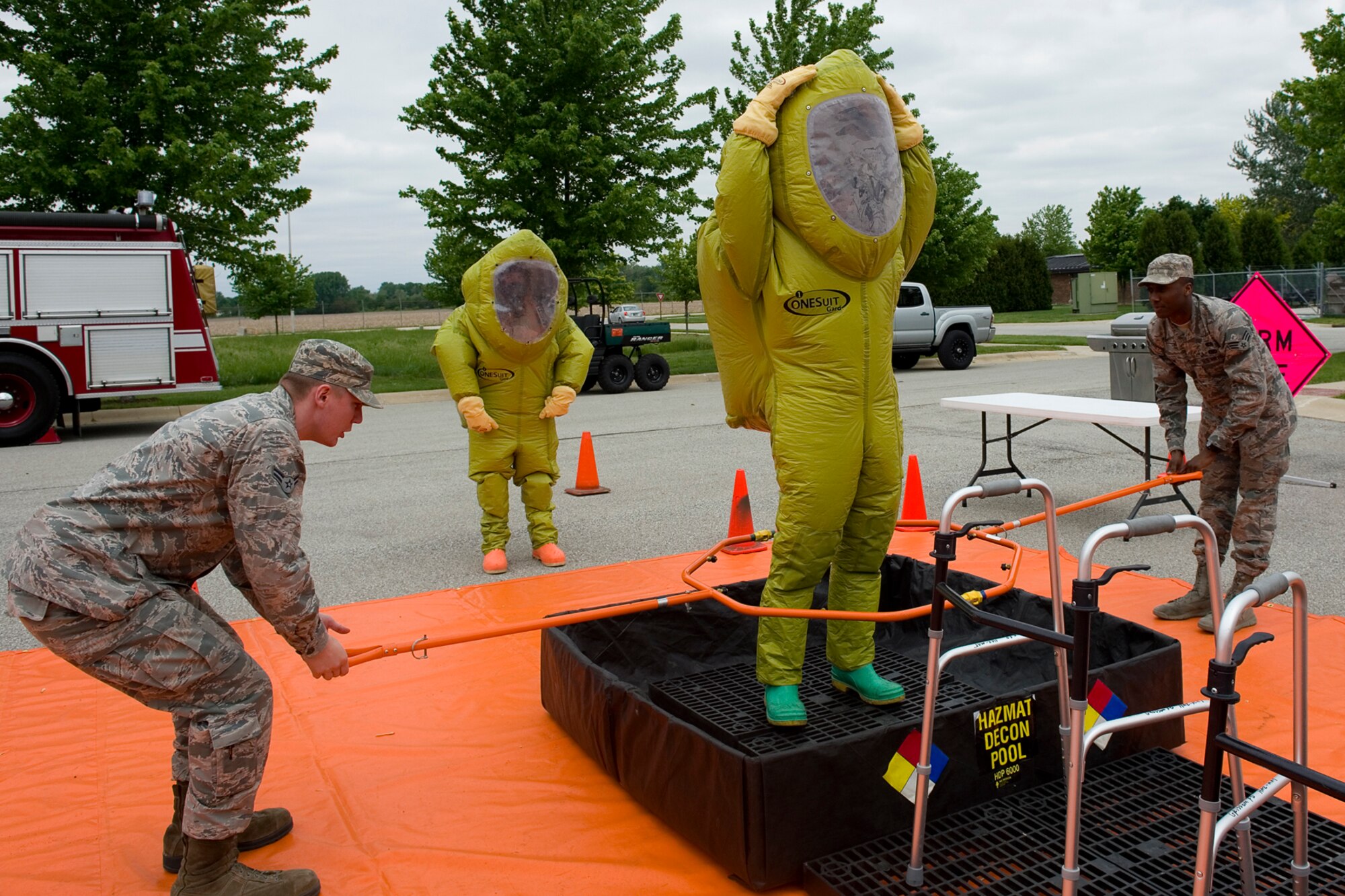 Airman 1st Class Joshua Knisley, 375th Civil Engineer Squadron emergency management specialist from Scott Air Force Base, Ill., and Senior Airman Brandon Stone, 509th Civil Engineer Squadron EM specialist from Whiteman Air Force Base, Mo., simulate the removal of hazardous material from Staff Sgt. Mitchell Birdsong, 60th Civil Engineer Squadron EM specialist from Travis Air Force Base, Calif., during an exercise at Grissom Air Reserve Base, Ind., May 19, 2015. The exercise was part of a 10-day course that allowed EM specialists from five major commands to unite and hone EM principals while incorporating combat skills and obtaining mandated recertifications. (U.S. Air Force photo/Tech. Sgt. Benjamin Mota)
