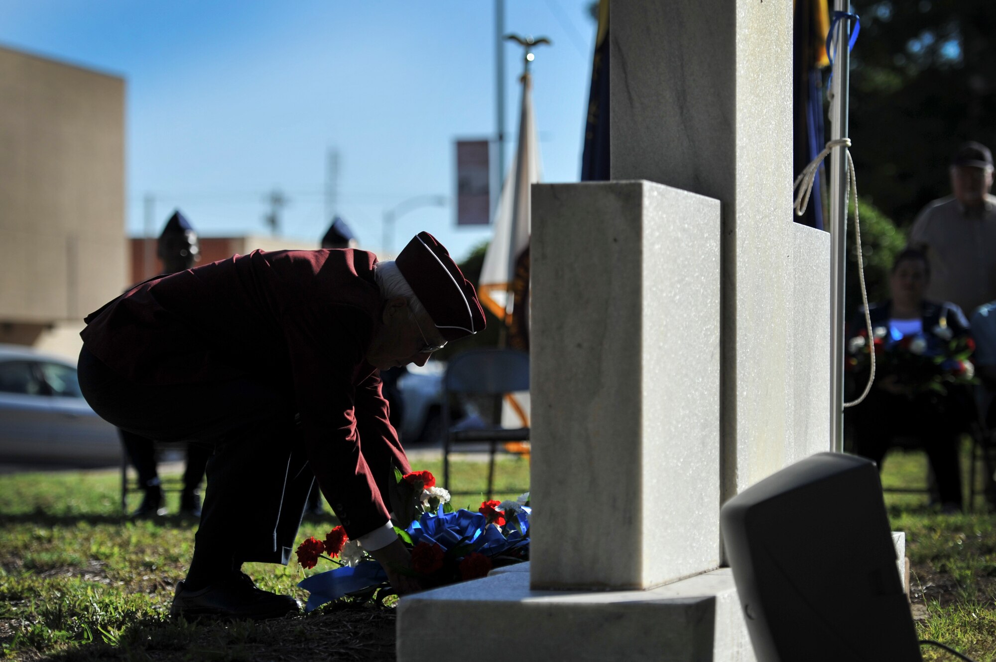 A representative from American Ex-Prisoners of War places flowers on the veteran memorial during the Memorial Day Ceremony at the Tom Green County Courthouse in San Angelo, Texas, May 26, 2015. The ceremony paid tribute to those who have lost their lives in all branches of the military. (U.S. Air Force photo by Senior Airman Michael Smith/Released)