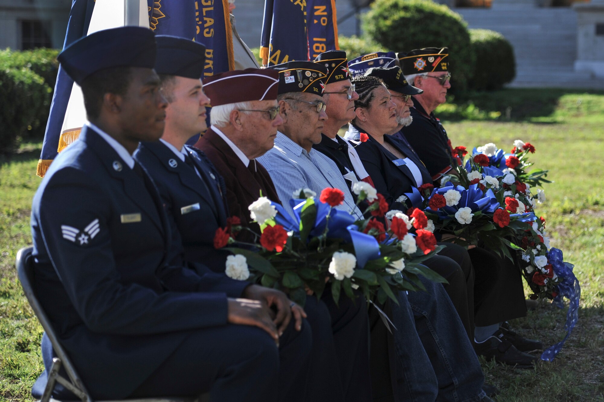 Representatives of various active duty and retired military organizations hold bouquets of flowers during the Memorial Day Ceremony at the Tom Green County Courthouse in San Angelo, Texas, May 26, 2015. The flowers were later laid upon the veteran memorial. (U.S. Air Force photo by Senior Airman Michael Smith/Released)