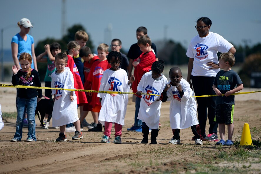Schriever Air Force Base School Age Program youth wait at the starting line to begin the America’s Armed Forces Kids Run May 15, 2015 at Schriever Air Force Base, Colo. Since 2002, the run has been a part of Armed Forces Day activities as military dependents from the U.S., Puerto Rico, Germany, Japan, England and Italy participate. (U.S. Air Force photo/Christopher DeWitt)