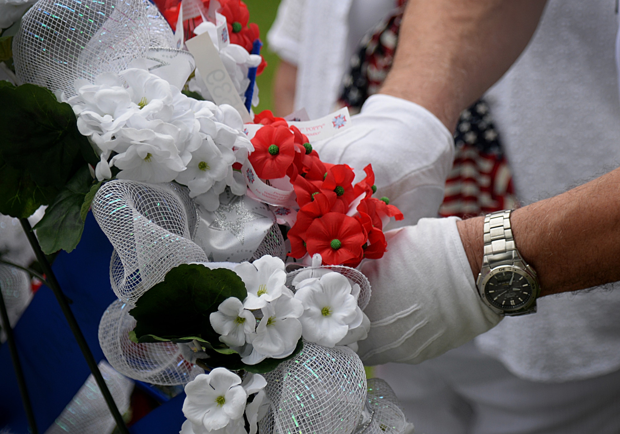 The D’Iberville, Mississippi Veterans of Foreign Wars group post commander puts a poppy flower on a wreath at the 2015 Biloxi National Cemetery Memorial Day ceremony, May 25, 2015, Biloxi, Miss. Local veterans, family members and Keesler Air Force Base and Naval Construction Battalion Center leadership attended to honor and remember the lives of fallen U.S. military heroes. (U.S. Air Force photo by Senior Airman Holly Mansfield)