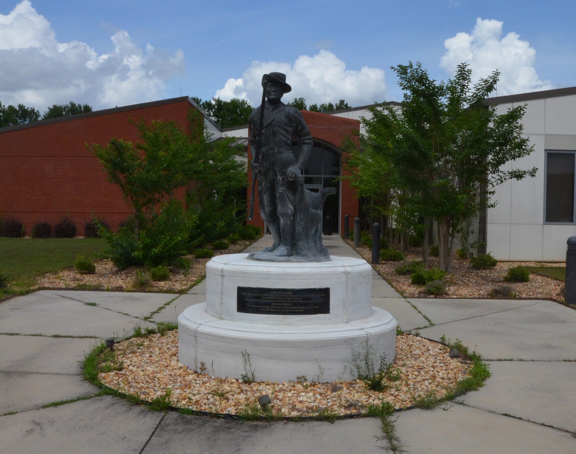 The Minuteman statue stands proudly in front of the 116th Force Support Squadron, Robins Air Force Base, Ga., May,26, 2015.  Now as a symbol of the National Guard, minutemen were once members of teams of select men from the American colonial partisan militia during the American Revolutionary War. They provided a highly mobile and rapidly deployed force that allowed the colonies to respond quickly to the threat of war.   (U.S. Air National Guard photo by Tech. Sgt. Julie Parker/Released)