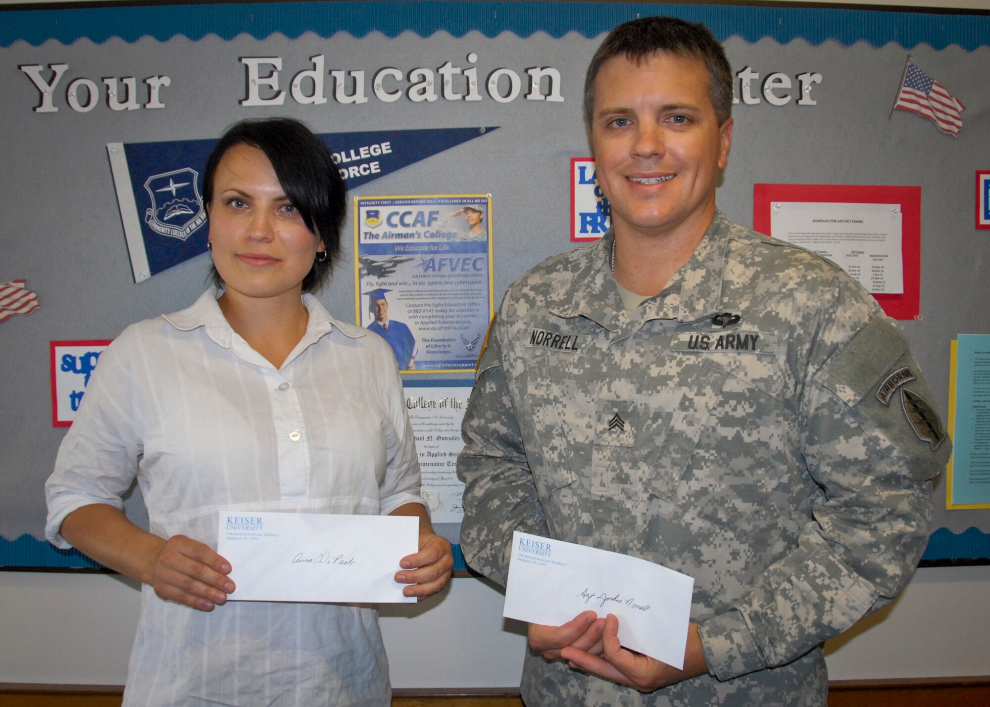 Anna Di Paolo, spouse of Sgt. Sean Di Paolo, a member of 7th Special Forces Group, and Sgt. Joshua Norrell, a 7th SFG member, receive $1,000 scholarships from the Florida Advisory Council on Military Education at Eglin Air Force Base, Florida’s education center May 21.  FL-ACME awards scholarships annually to provide educational opportunities for eligible service members, their families, reserve/guard and retired service members.  (U.S. Air Force photo/Kevin Gaddie)    