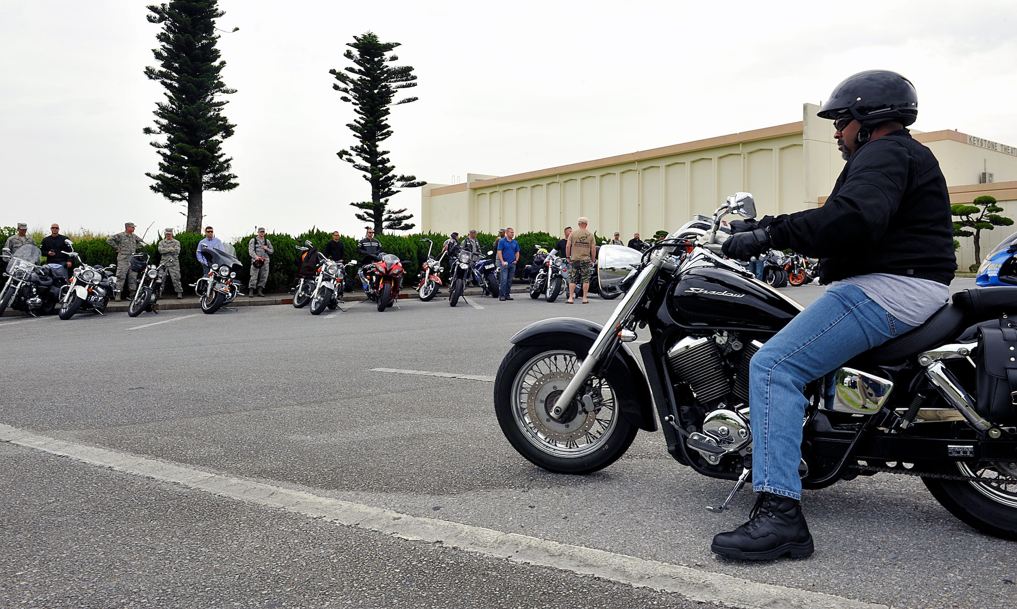 Approximately 50 bike riders participate in the semi-annual Motorcycle Safety Stand Down during the Wingman Safety Day at the Keystone Theater on Kadena Air Base, Japan, May 21, 2015. Bike riders paraded around Kadena Air Base led by an 18th Security Forces Squadron patrol car after a safety brief. The Wingman Safety Day is an Air Force-wide program that offers a pause in the mission focus in order to solidify relationships and emphasize making responsible choices. (U.S. Air Force photo by Naoto Anazawa)