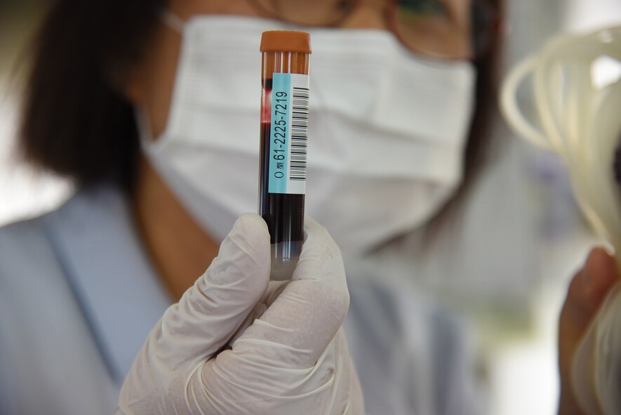 A vial of blood is held up for inspection by a member of the Japanese Red-Cross during a blood drive held at Misawa Air Base, Japan, May 27, 2015. After blood is collected from a patient, the blood is transferred to a centrifuge for examination and grouped with a patient’s other samples.  (U.S. Air Force photo by Senior Airman Patrick S. Ciccarone/Released)