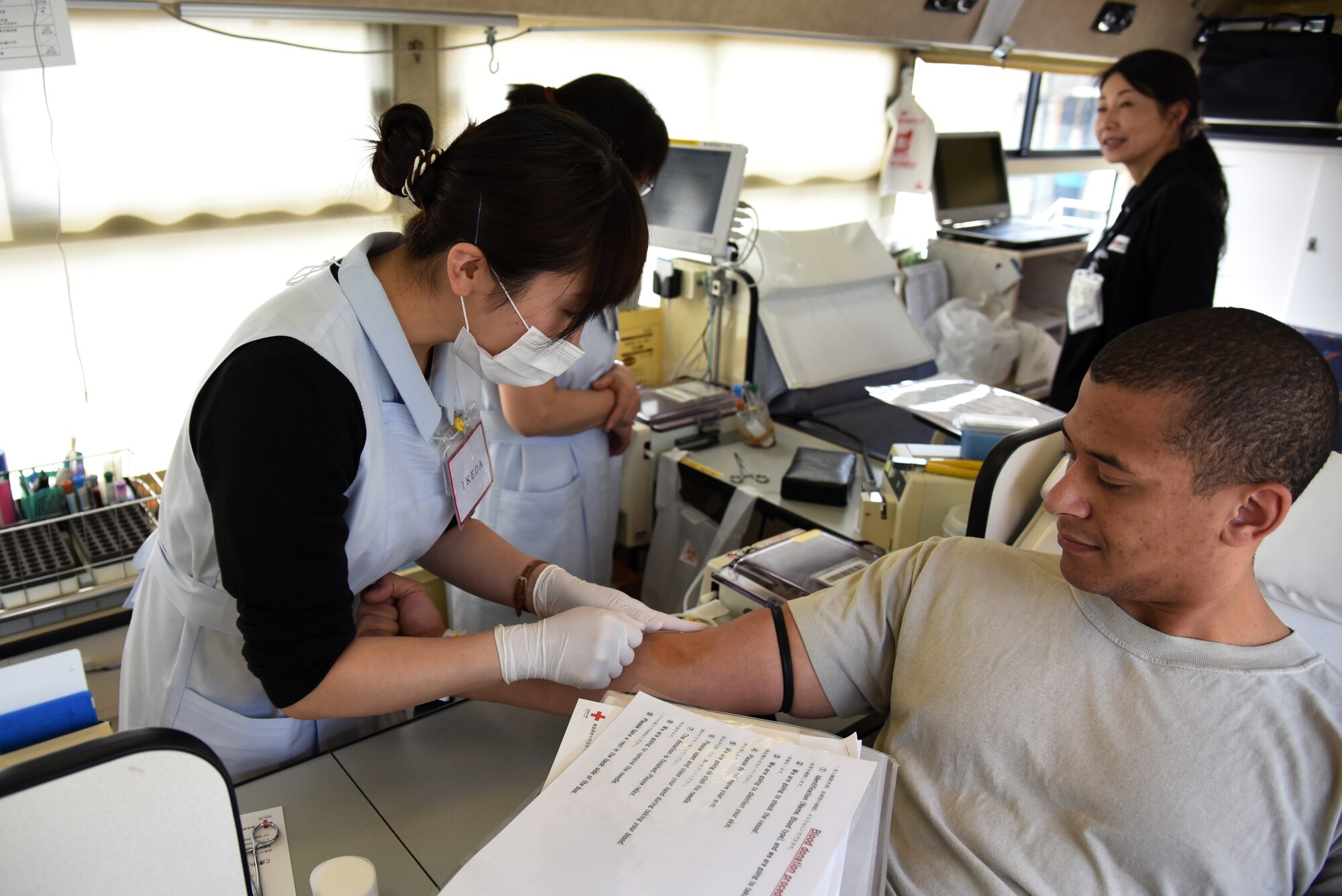 A member from the Japanese Red Cross extracts blood from U.S. Air Force Staff Sgt. Joshua Poole, 35th Logistic Readiness Squadron vehicle maintenance support technician, during a blood drive at Misawa Air Base, Japan, May 27, 2015. Poole is one of many individuals from the Misawa community to donate blood. (U.S. Air Force photo by Senior Airman Patrick S. Ciccarone/Released)