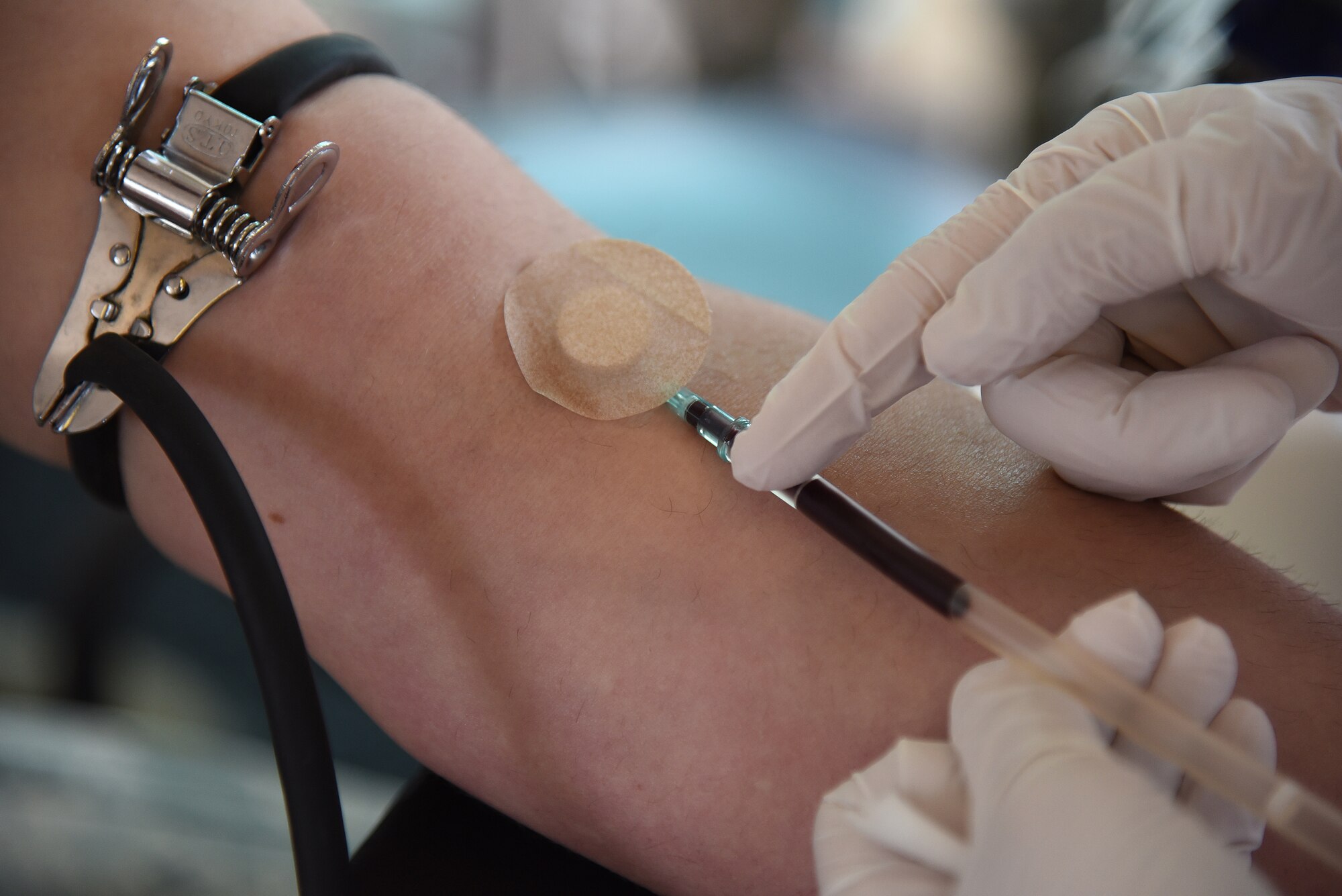 A Japanese Red Cross phlebotomist collects blood from a patients arm during a blood drive at Misawa Air Base, Japan, May 27, 2015. The technician prepared the patient’s arm for extraction by swabbing the extremity with alcohol, ensuring the area is sterile for insertion. After blood is extracted, the technician will conduct a hemoglobin test to determine if the blood is healthy.  (U.S. Air Force photo by Senior Airman Patrick S. Ciccarone/Released)