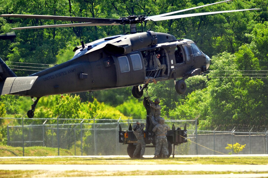 U.S. soldiers attach the sling lines to a UH-60L Black Hawk helicopter during slingload training on Camp Carroll, Waegwan, South Korea, May 21, 2015.