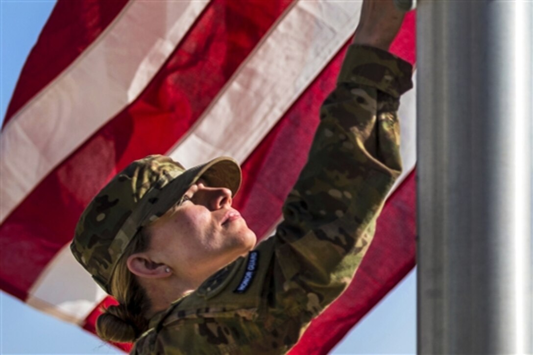 U.S. Air Force Senior Airman Chelsea Shields helps lower the flag during a Memorial Day retreat ceremony on Bagram Airfield, Afghanistan, May 25, 2015. Shields is assigned to the 455th Air Expeditionary Wing.