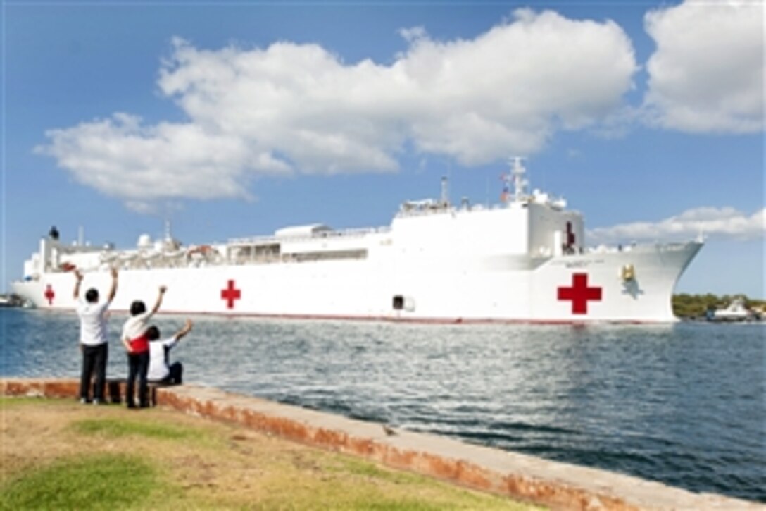 Onlookers wave to the Military Sealift Command hospital ship USNS Mercy as it arrives at Joint Base Pearl Harbor-Hickam, Hawaii, May 25, 2015, to support Pacific Partnership 2015. Pacific Partnership is the largest annual multilateral humanitarian assistance and disaster relief preparedness mission conducted in the Indo-Asia-Pacific region.
