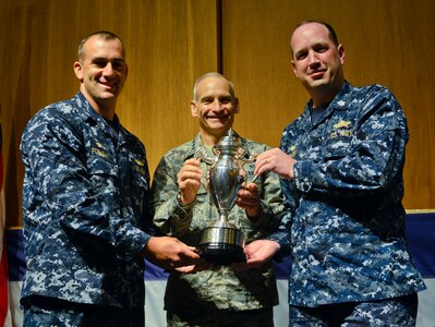 U.S. Air Force Lt. Gen. James M. Kowalski (center), U.S. Strategic Command deputy commander, presents the 2014 Omaha Trophy, ballistic missile submarine category, to the commanding officers of the Ohio-class ballistic missile submarine USS Alaska (SSBN 732), Kings Bay, Ga., May 27, 2015. U.S. Navy Cmdr. David Forman (left), Blue crew commander, and U.S. Navy Cmdr. Craig Gummer, Gold crew commander, accepted the trophy of behalf of their respective crews. The USS Alaska is one of four Omaha Trophy-winning units for 2014 and joins winners in the intercontinental ballistic missile wing, global operations (space/cyberspace) and strategic aircraft operations categories. Those receiving the awards represent units throughout USSTRATCOM which are critical to fulfilling the combatant command's primary mission: to detect, deter and prevent strategic attacks against the United States and its allies. USSTRATCOM is one of nine DoD unified combatant commands and is charged with strategic deterrence; space operations; cyberspace operations; joint electronic warfare; global strike; missile defense; intelligence, surveillance and reconnaissance; combating weapons of mass destruction; and analysis and targeting. (U.S. Navy photo by Mass Communication Specialist 1st Class Rex Nelson)
