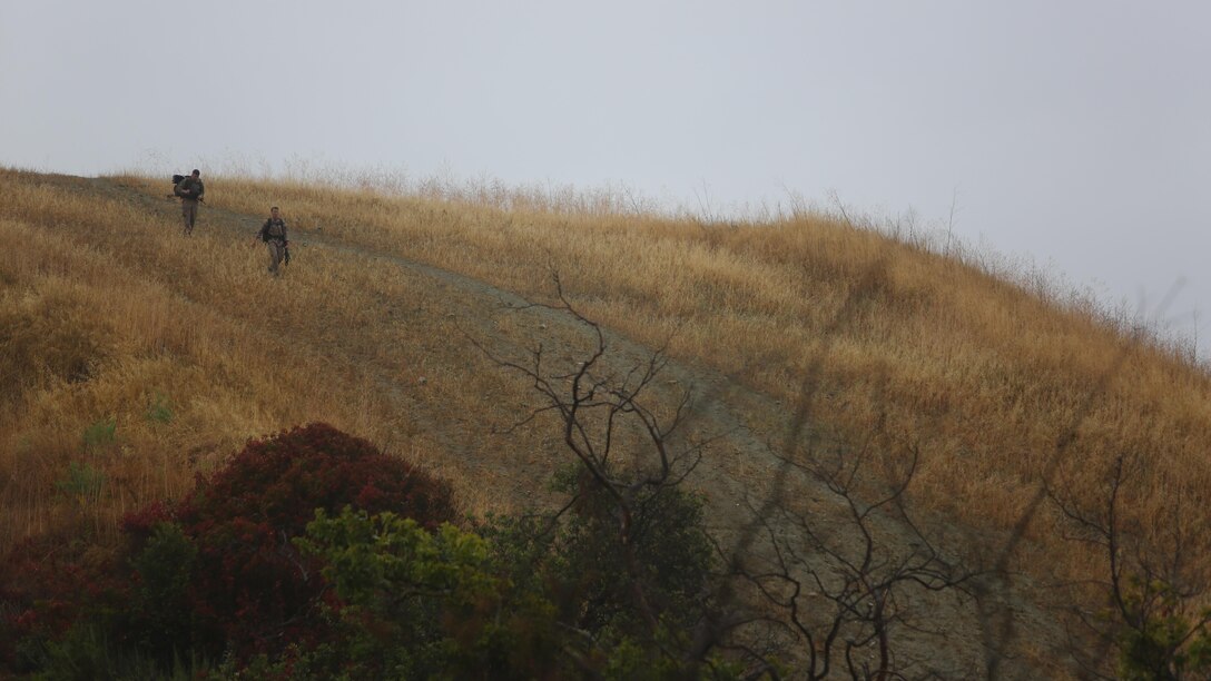 Competitors trek through the mud and hills to complete the 7th Annual Recon Challenge aboard Marine Corps Base Camp Pendleton, California, May 15, 2015. With rain pouring down their backs, competitors completed 11 stations spread across more than 25 miles.