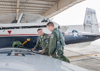 Maj. Todd Salzwedel (left), 559th Flying Training Squadron director of staff, demonstrates final check procedures to a 558th Flying Training Squadron remotely piloted aircraft instrument qualification student, prior to his first orientation flight in a T-6 Texas II May 12 at Joint Base San Antonio-Randolph, Texas. This is the first class to get a real world feel of what manned pilots experience in a combat environment, offers validation of their training and provides a different perspective than what they receive in a simulator. (U.S. Air Force photo by Melissa Peterson)