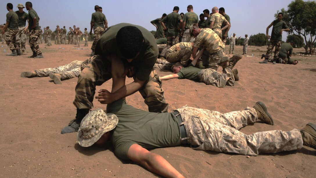 A Royal Moroccan Armed Forces soldier takes down a U.S. Marine while practicing techniques from a nonlethal-combative workshop during Exercise African Lion 15, May 15, in Tifnit, Morocco. The Royal Moroccan, U.S., U.K., Netherlands, and Belgian Armed Forces integrated while conducting peacekeeping support training to improve military capabilities and operational familiarity as one international coalition.