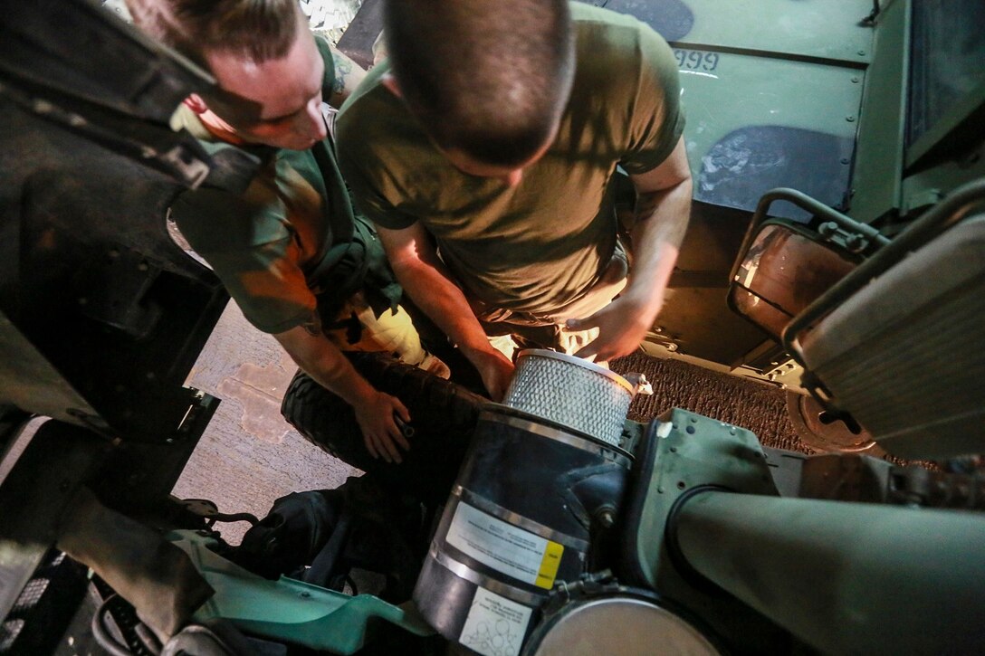 U.S. Marine Cpl. Donald R. Tippie, right, replaces the air filter on a Humvee aboard the USS Anchorage (LPD 23) at sea in the Pacific Ocean, May 25, 2015. Tippie is a motor transportation quality control chief with the Command Element, 15th Marine Expeditionary Unit. The Marines of the 15th MEU constantly perform maintenance on their equipment to maintain combat readiness. (U.S. Marine Corps photo by Cpl. Steve H. Lopez/Released)
