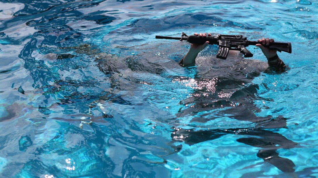 Master Sgt. Vincent Marzi, the operations chief for 1st Reconnaissance Company, rises from the water with his rifle during an aquatic event during the 7th Annual Recon Challenge aboard Marine Corps Base Camp Pendleton, California, May 15, 2015. Competitors were tested on their swimming capabilities before the challenge began to ensure they were able to complete the aquatic events.