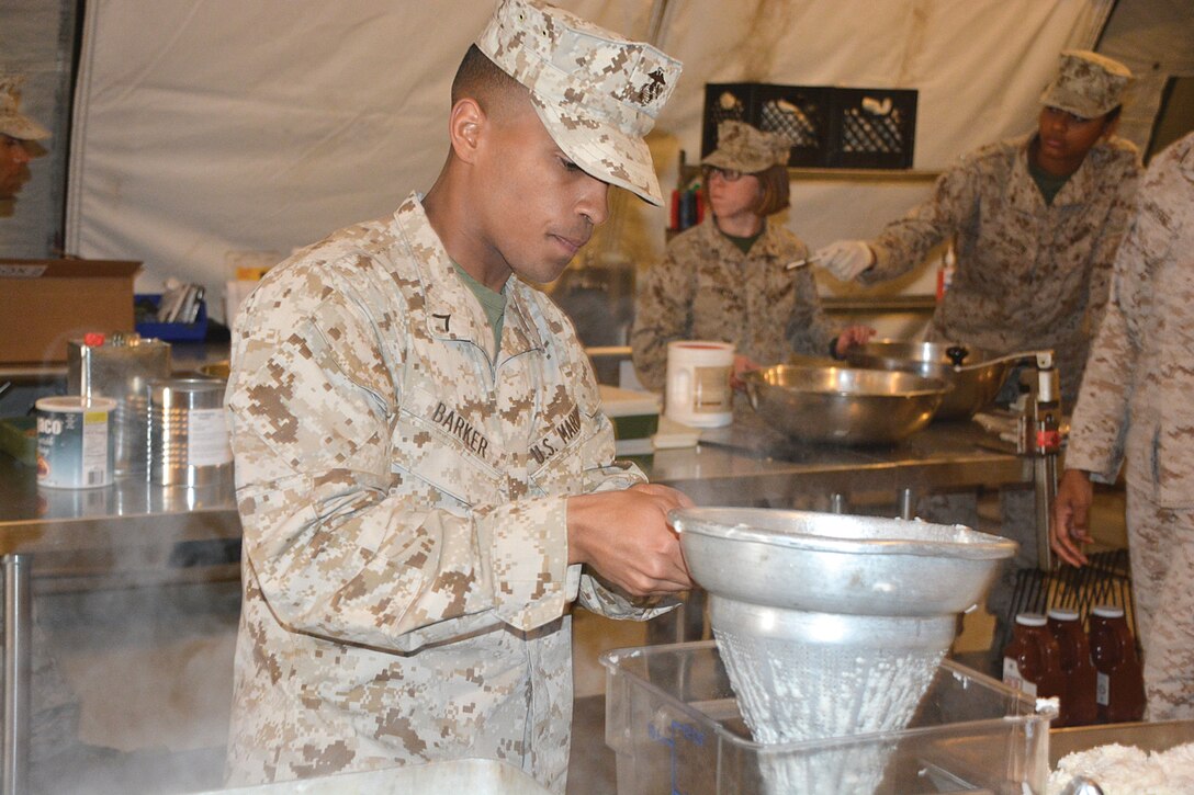 Pfc. Frank Barker, a Marine student in class 027-15, drains water out of rice as part of the final meal March 24 in his training. (Photo by Amy Perry, Fort Lee Public Affairs)