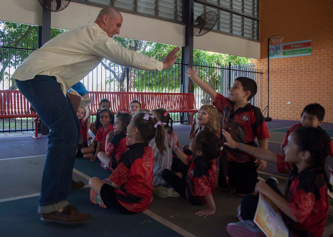 Lance Corporal Matthew Fahey, a Monroe, Connecticut native, hive-fives with a group of children May 8 at Alawa Primary School, Alawa, Northern Territory, Australia. U.S. Marines are good neighbors who are engaged with and contribute to Australian communities. Fahey is a helicopter airframe mechanic with Heavy Marine Helicopter Squadron 463, Marine Rotational Force - Darwin.