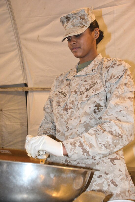 Pfc. Vella Jackson, a Marine student in class 027-15, rolls oatmeal cookies into balls to prepare them for baking as part of the final meal March 24 in her training. (Photo by Amy Perry, Fort Lee Public Affairs)