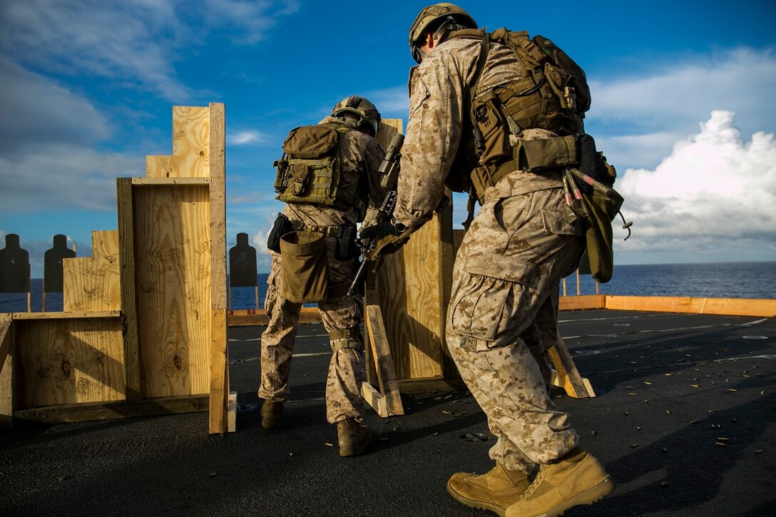 U.S. Marines with the 15th Marine Expeditionary Unit’s Maritime Raid Force practice marksmanship tactics on the flight deck of the USS Essex (LHD 2) at sea in the Pacific Ocean, May 28, 2015. The Marines focused on moving through the doorway swiftly while maintaining accuracy with their shots. (U.S. Marine Corps photo by Cpl. Anna Albrecht/ Released)