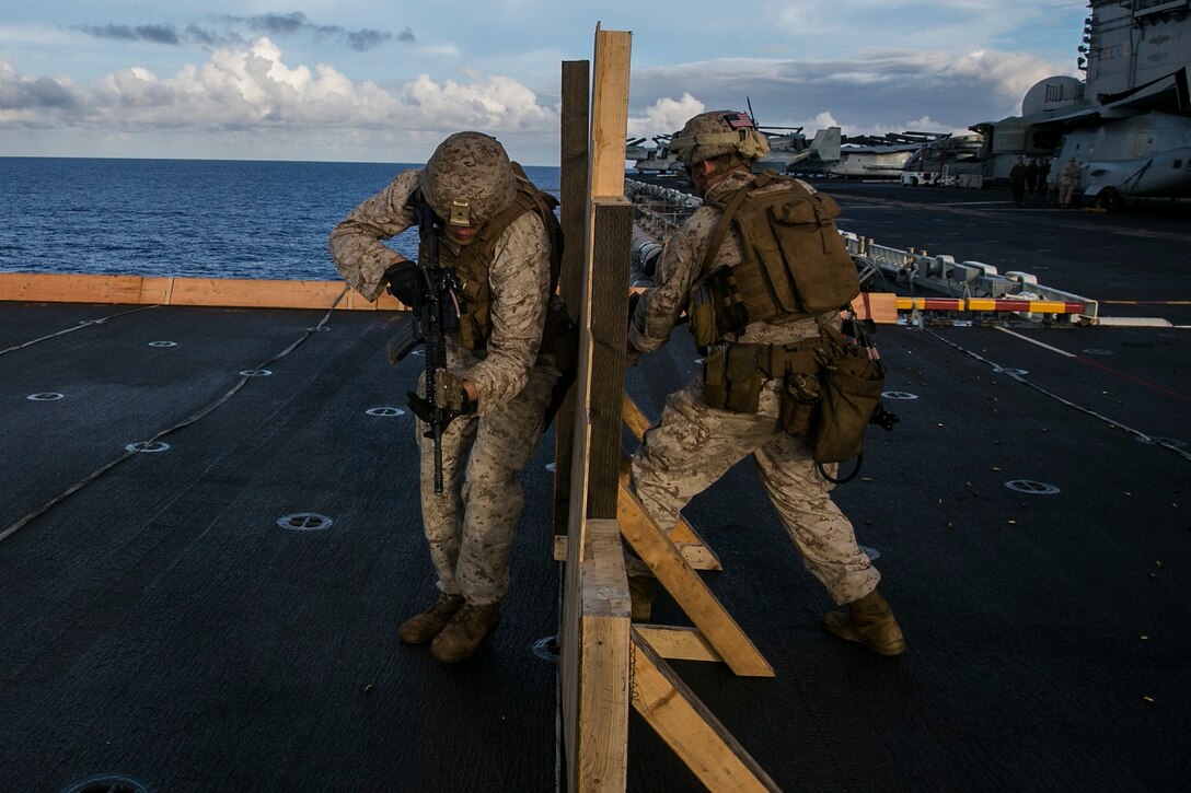U.S. Marines with the 15th Marine Expeditionary Unit’s Maritime Raid Force practice room-entering procedures on the flight deck of the USS Essex (LHD 2) at sea in the Pacific Ocean, May 28, 2015. These Marines were executing drills that simulate entering a room with two men and immediately seeing a target. (U.S. Marine Corps photo by Cpl. Anna Albrecht/ Released)