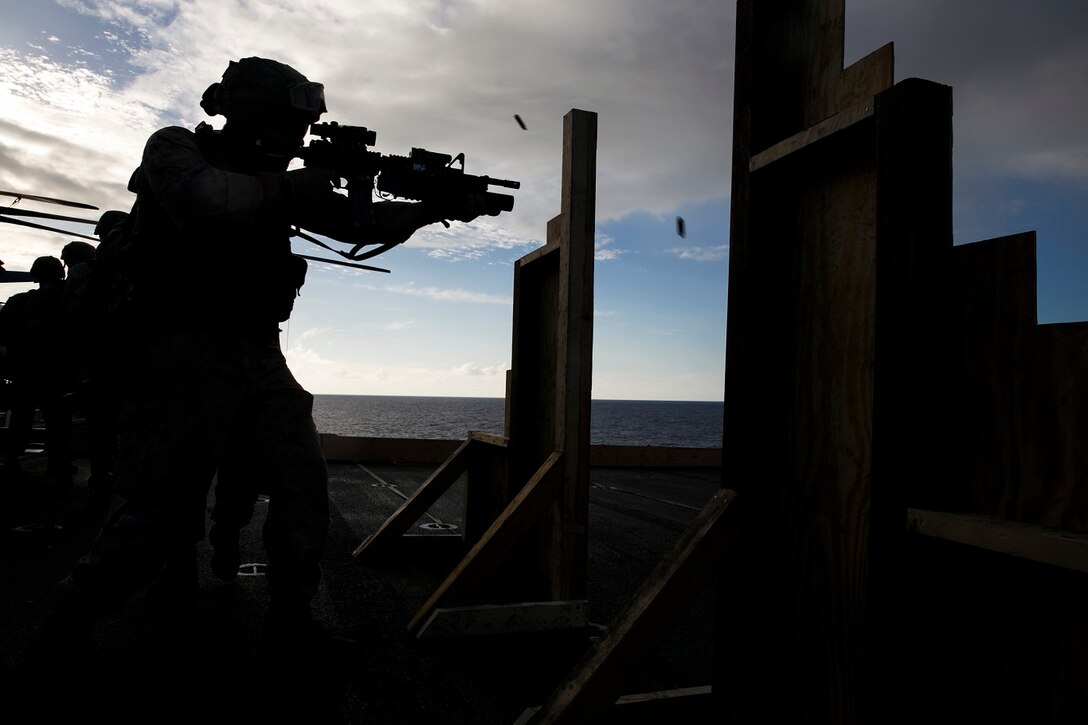 A U.S. Marine with the 15th Marine Expeditionary Unit’s Maritime Raid Force shoots at his target on the flight deck of the USS Essex (LHD 2) at sea in the Pacific Ocean, May 28, 2015. These Marines were executing drills that simulate entering a room and immediately seeing a target. (U.S. Marine Corps photo by Cpl. Anna Albrecht/ Released)