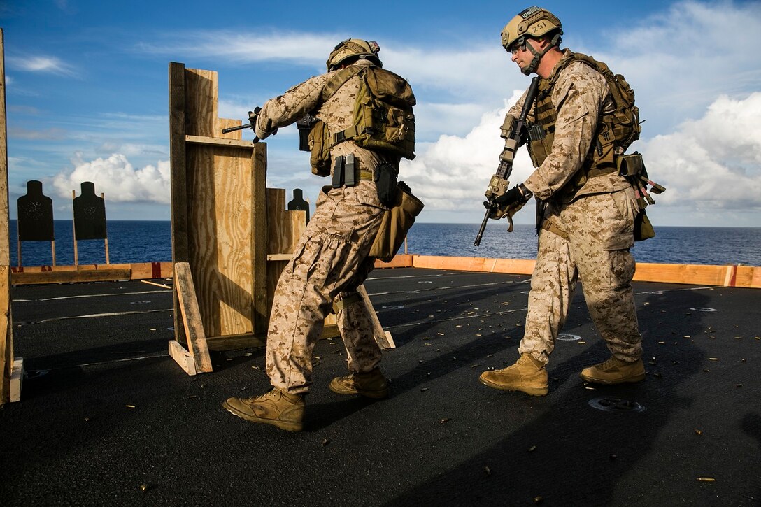 U.S. Marines with the 15th Marine Expeditionary Unit’s Maritime Raid Force practice marksmanship tactics on the flight deck of the USS Essex (LHD 2) at sea in the Pacific Ocean, May 28, 2015. The Marines focused on moving through the doorway swiftly while maintaining accuracy with their shots. (U.S. Marine Corps photo by Cpl. Anna Albrecht/ Released)