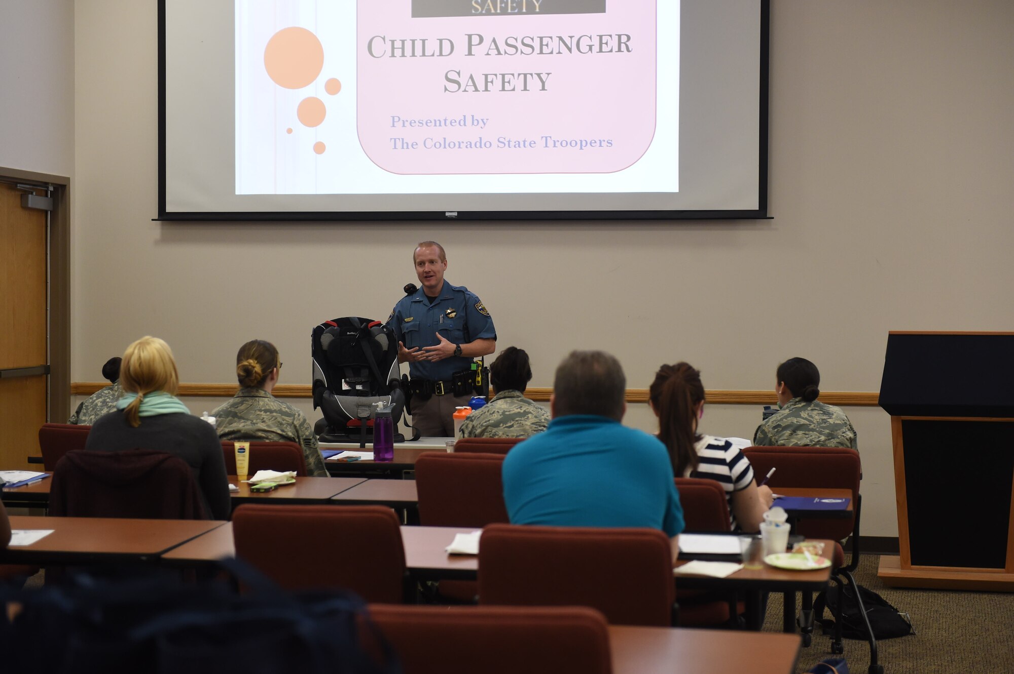 Josh Lewis, Colorado State Trooper, speaks to expecting Team Buckley members on the importance of car seat safety during Bundles for Babies May 27, 2015, on Buckley Air Force Base, Colo. The class is offered to expecting and new parents and covers a range of topics such as car seat safety, nutrition, fitness, mental health, dividing childcare and chores, navigating common disagreements between spouses, and a family budgeting session. At the end of the class, each family gets to take home a “bundle” that contains bibs, onesies, pajamas, burp towels, bath towels, crib sheets and mittens sponsored by the Air Force Aid Society. (U.S Air Force photo by Airman 1st Class Samantha Meadors/Released)