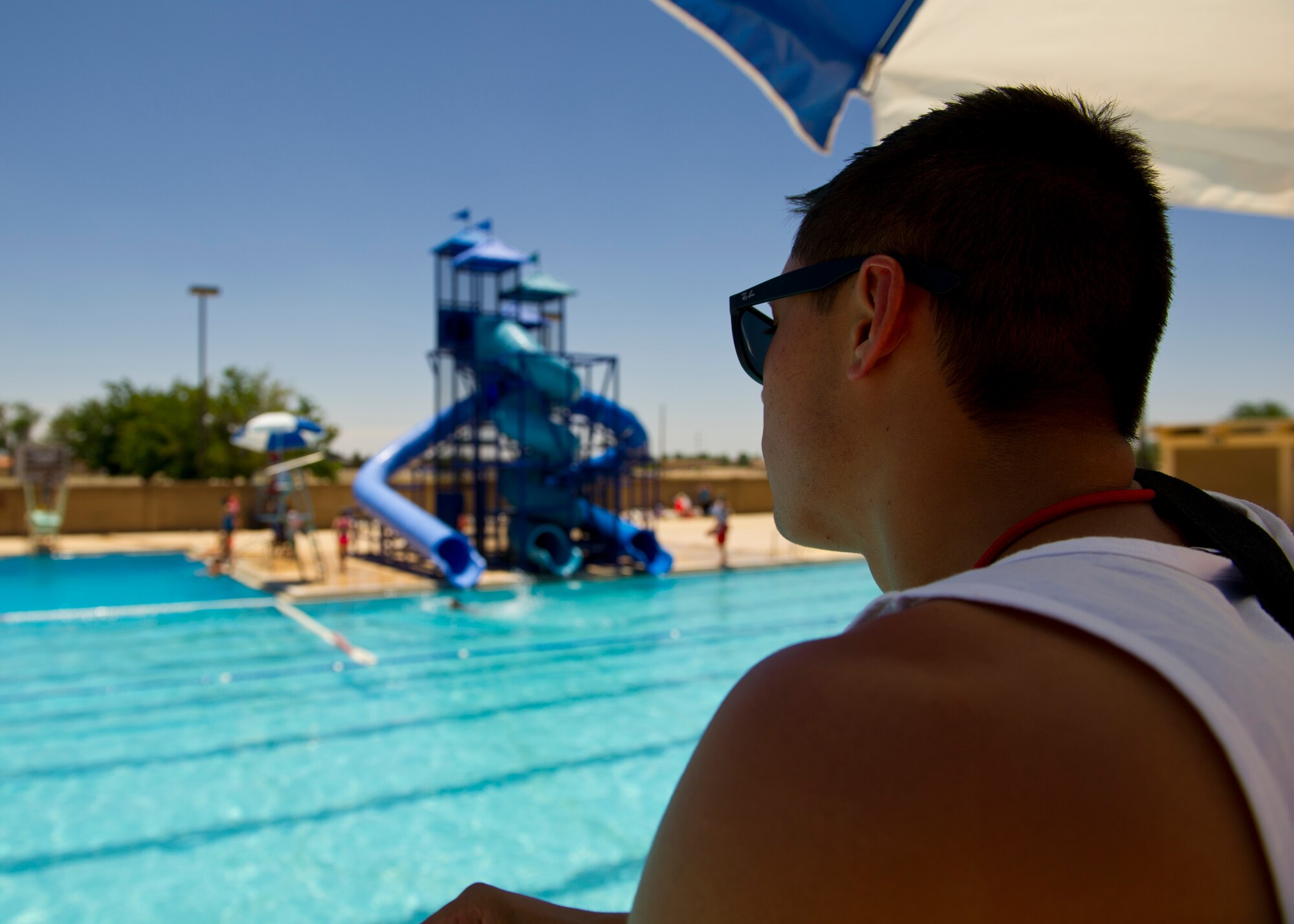 Niko Tran, Aquatic Center life guard watches over the pool at the Aquatic Center at Holloman Air Force Base, N.M., May 28, 2015. The Aquatic Center opened its doors for the summer offering an “oasis” for members of Team Holloman escaping New Mexico’s high summer temperatures. The pool is open seven days a week, and now offers free admission for military card holders all summer long. (U.S. Air Force photo by Senior Airman Leah Ferrante/Released)