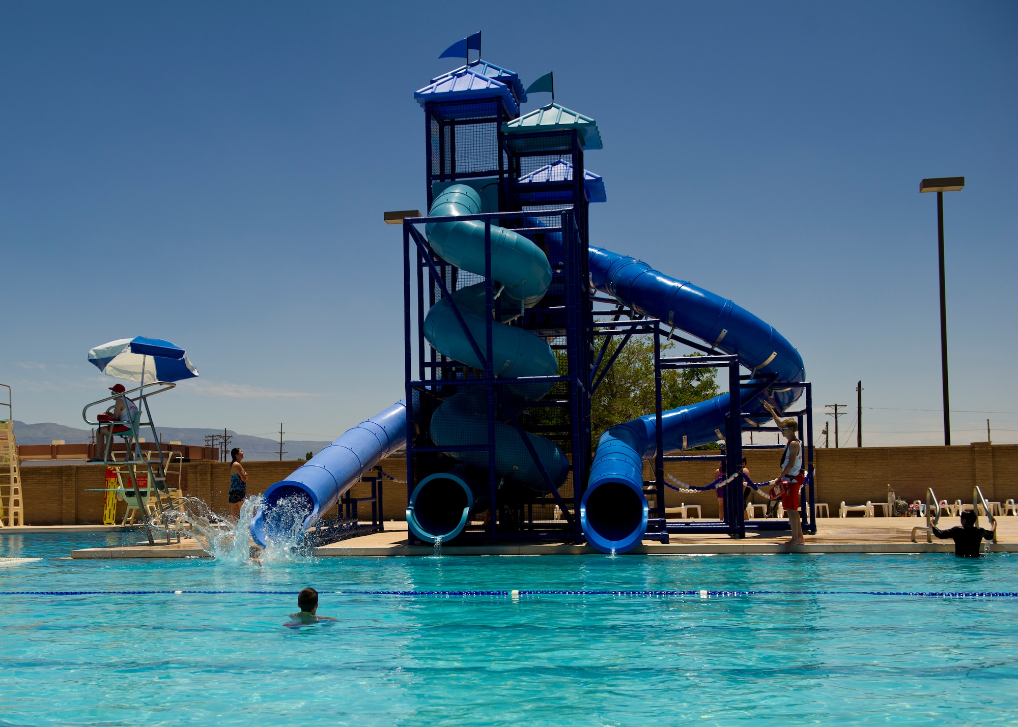 Members of Team Holloman use the new water slide tower that consists of three slides at the Aquatic Center at Holloman Air Force Base, N.M., May 28, 2015. The Aquatic Center opened its doors for the summer offering an “oasis” for members of Team Holloman escaping New Mexico’s high summer temperatures. The pool is open seven days a week, and now offers free admission for military card holders all summer long. (U.S. Air Force photo by Senior Airman Leah Ferrante/Released)