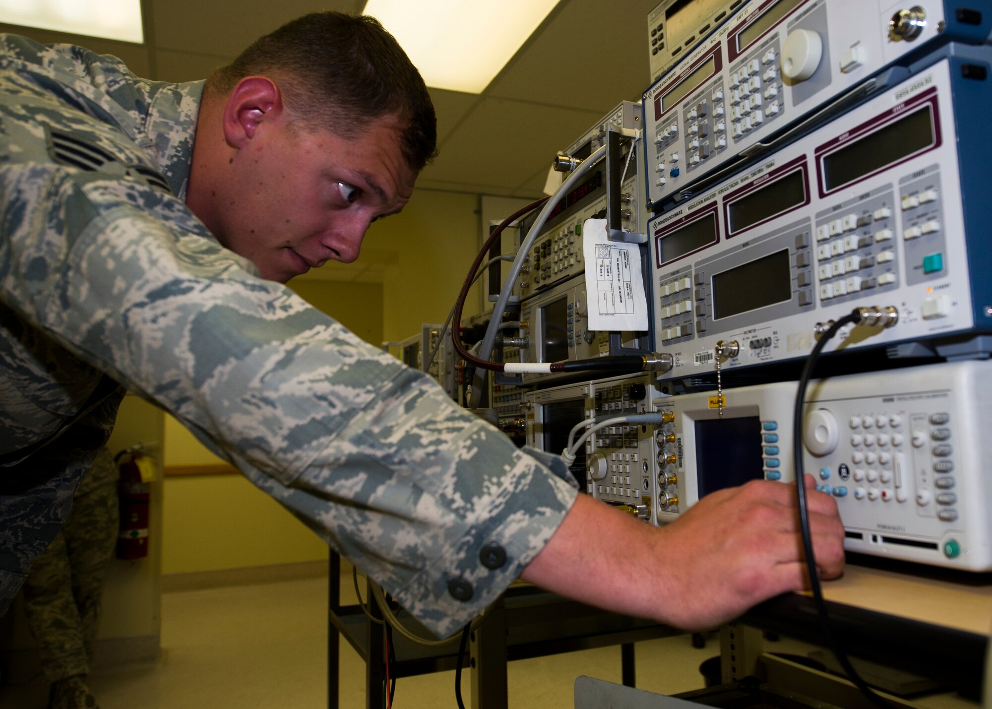 Senior Airman Trace Taft, a Precision Measurement Equipment Laboratory technician with the 49th Maintenance Squadron, checks a radio test set at PMEL May 28, 2015 at Holloman Air Force Base, N.M. Radio test sets are used to test beacons for pilots in case of an emergency ejection. (U.S. Air Force photo by Airman 1st Class Emily A. Kenney/Released)