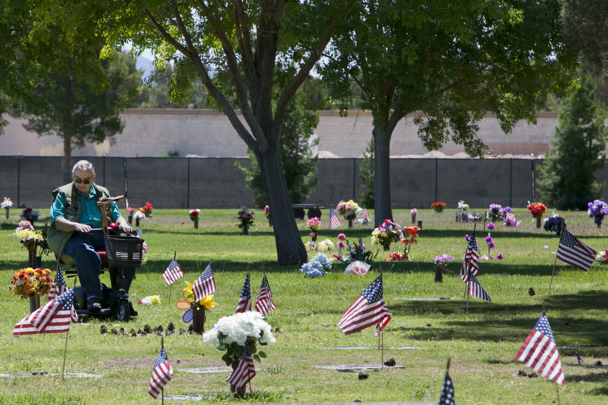 A disabled veteran pays respect to a fellow veteran during Memorial Day at the Davis Funeral Homes and Memorial Park in Las Vegas, May 25. Memorial Day is a day to reflect on those veterans and military personnel who are deceased. (U.S. Air Force photo by Lorenz Crespo)  