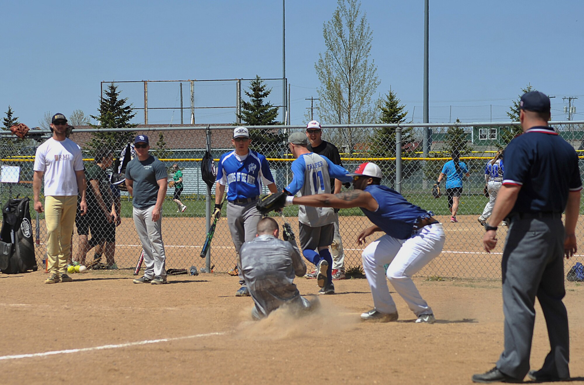 Senior Airman Carl “Eddie” Miller, 348th Reconnaissance Squadron member from Grand Forks Air Force Base, slides home during the second all-male game of the Grand Forks AFB vs. Minot AFB softball tournament at Roosevelt Park in Devils Lake, N.D., May 21, 2015. The tournament was the first time the two bases came together on the field of play for a morale boosting event. (U.S. Air Force photo by Airman 1st Class Bonnie Grantham/Released)