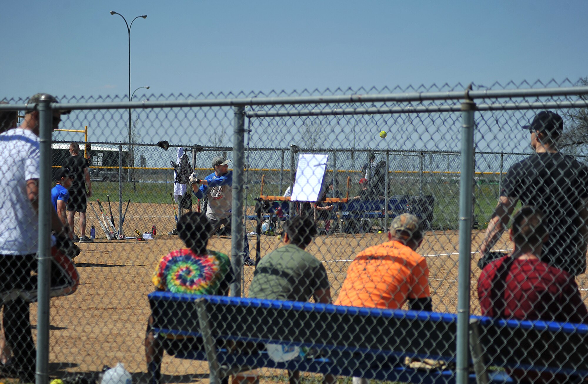 Airmen from Grand Forks Air Force Base sit in the dug out and wait to bat during a scrimmage before the Minot AFB vs. Grand Forks AFB softball tournament at Roosevelt Park in Devils Lake, N.D., May 21, 15.  The Grand Forks AFB team won two out of the three competitive games, earning them the winning trophy. The tournament was the first time the two bases came together on the field of play for a morale boosting event. (U.S. Air Force photo by Airman 1st Class Bonnie Grantham/Released)