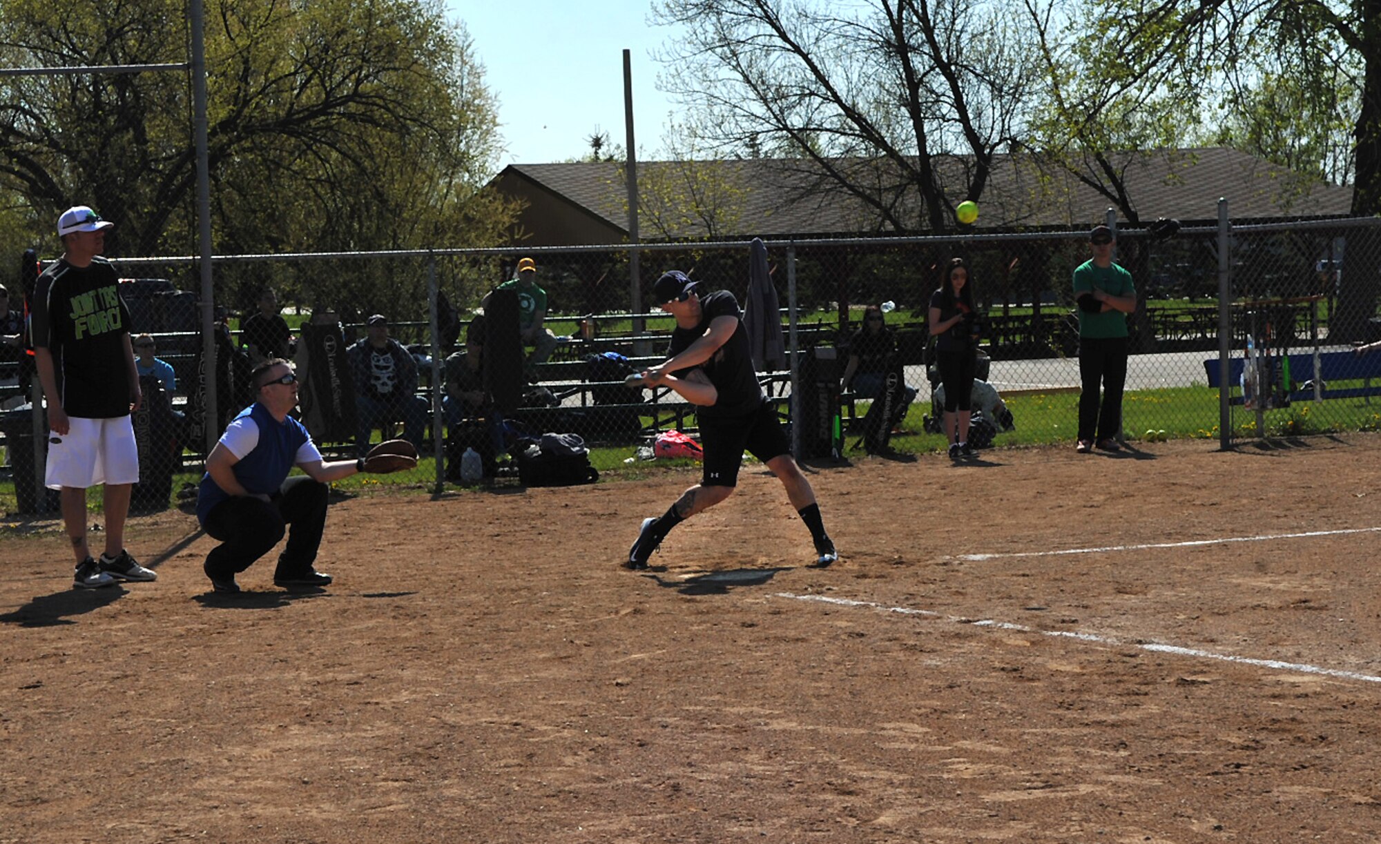 Airman 1st Class Andrew Liddane, 319th Logistics Readiness Squadron vehicle operator journeyman from Grand Forks Air Force Base, prepares to swing at a softball during a scrimmage before the Minot AFB vs. Grand Forks AFB softball tournament at Roosevelt Park in Devils Lake, N.D., May 21, 2015. The Grand Forks AFB team took home the trophy after winning two out of three competitive games. The tournament was the first time the two bases came together on the field of play for a morale boosting event. (U.S. Air Force photo by Airman 1st Class Bonnie Grantham/Released)