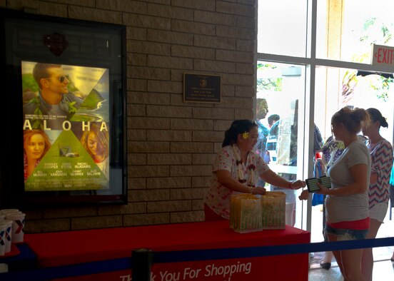 Military members and their families received free popcorn and soda during the premier of the movie “Aloha” at the Memorial Base Theater on Joint Base Pearl Harbor-Hickam, Hawaii, May 17, 2015. JBPHH provided a number of the movie's background characters and supporting roles, as well as air assets like the C-17 III Globemaster and F-22 Raptor. The production crew was also granted access to base real estate such as the Officer's Club, Fort Kameahaha housing, the flightline and the Pacific Air Forces commander's office, which also appeared in the movie. (U.S. Air Force photo by Tech. Sgt. Terri Paden/RELEASED)