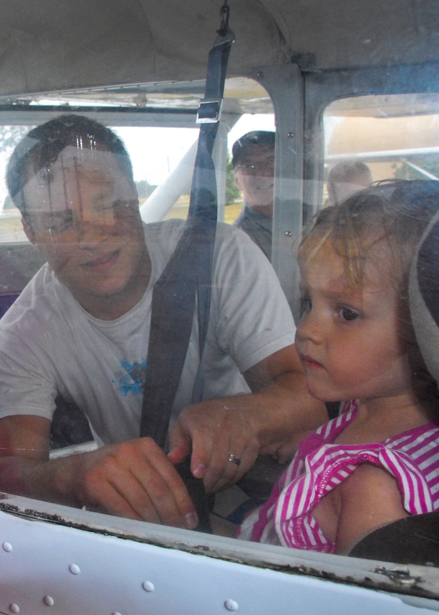 John Bryan, a 96th Communications Squadron member, secures his daughter Carlie, 2, into her child safety seat prior to taking a 20-minute Aero Club orientation flight May 25 at Eglin Air Force Base, Fla.  The Aero Club also offers anyone with base access the opportunity earn their private pilot’s license and many other airplane operator certifications. (U.S. Air Force photo/Kevin Gaddie)