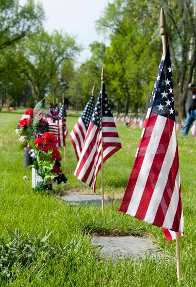 Flags are placed along graves during a Memorial Day event at Rosehill Cemetery in Minot, N.D., May 25, 2015. During the event, friends and families of those who have passed while serving in the armed forces placed flags on the graves of their loved ones. (U.S. Air Force photo/Airman 1st Class Sahara L. Fales)