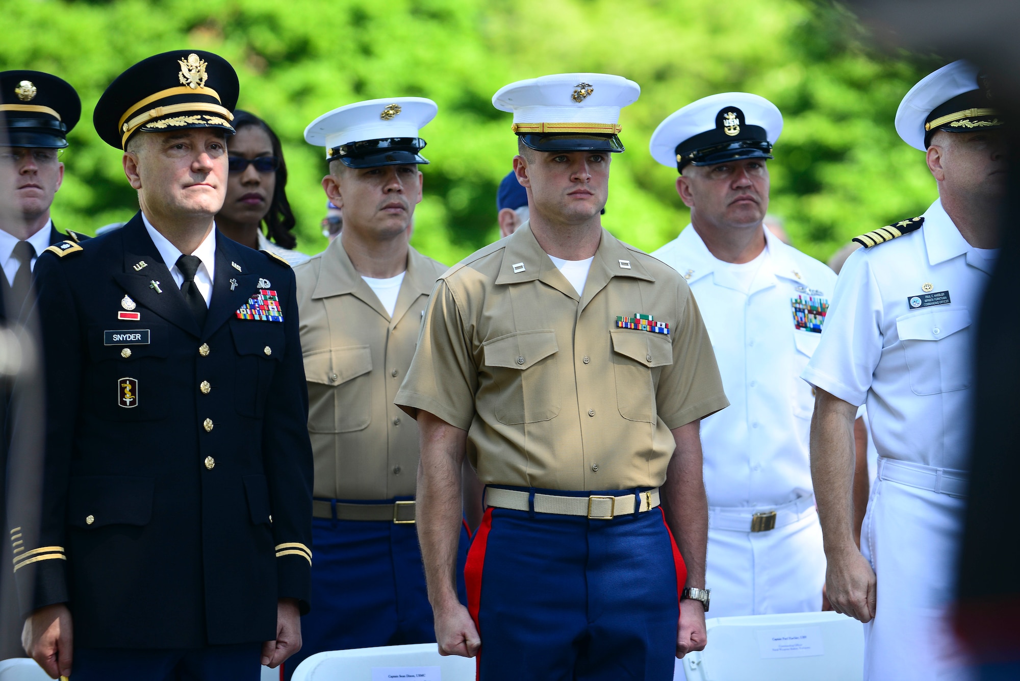 U.S. Service members stand as Taps is played during a Memorial Day Ceremony in Hampton, Va., May 25, 2015. Everyone in attendance stood in silence as the U.S. Fleet Forces Band played a song in tribute to fallen Service members. (U.S. Air Force photo by Senior Airman Kimberly Nagle/Released)  