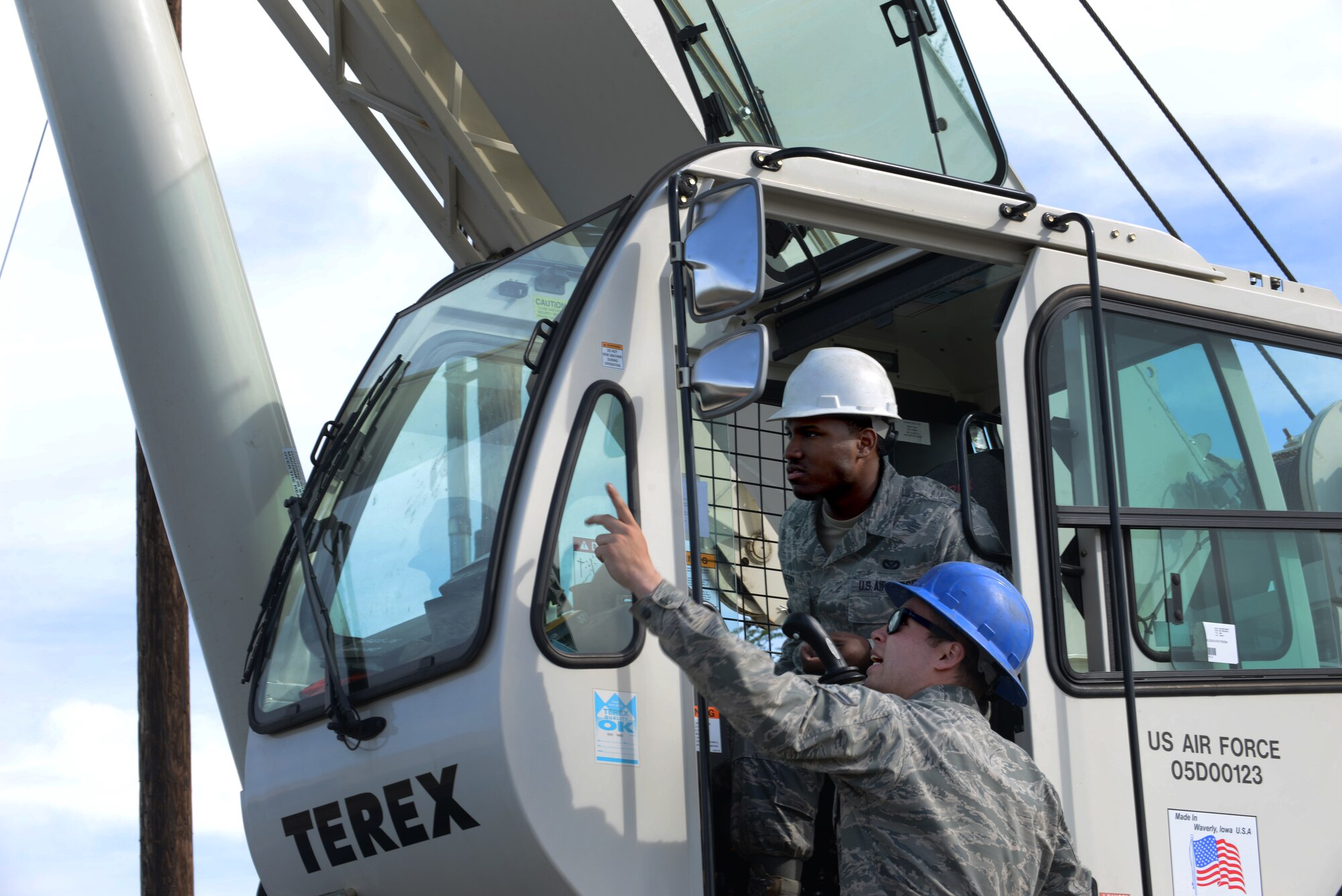 U.S. Air Force Senior Airman Gary Johnston III and Airman 1st Class Dre Perry, 354th Civil Engineer Squadron heavy equipment operators, discuss plans on lifting a Giant Voice speaker cell May 15, 2015, at Eielson Air Force Base, Alaska. The Dirt Boyz lent their support with crane operations, which quadrupled the speed of the Giant Voice replacement. (U.S. Air Force photo by Senior Airman Ashley Nicole Taylor/Released)