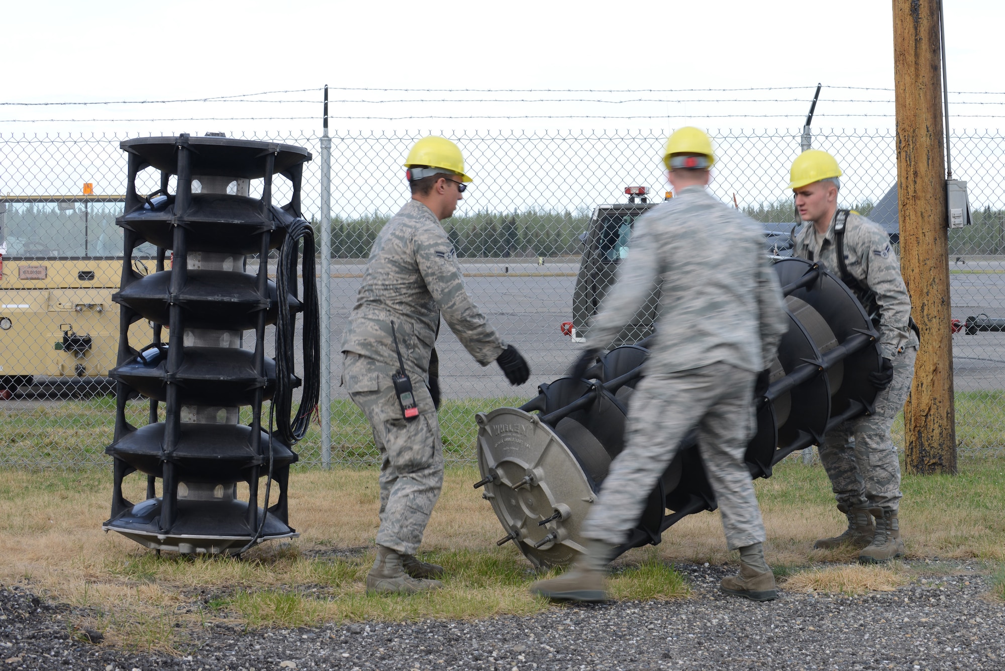 U.S. Air Force Airmen assigned to the 354th Communications Squadron transfer an old speaker cell to be replaced May 15, 2015, at Eielson Air Force Base, Alaska. All 19 posts on base will be exchanged with brand new speakers to the system’s enhance the. (U.S. Air Force photo by Senior Airman Ashley Nicole Taylor/Released)