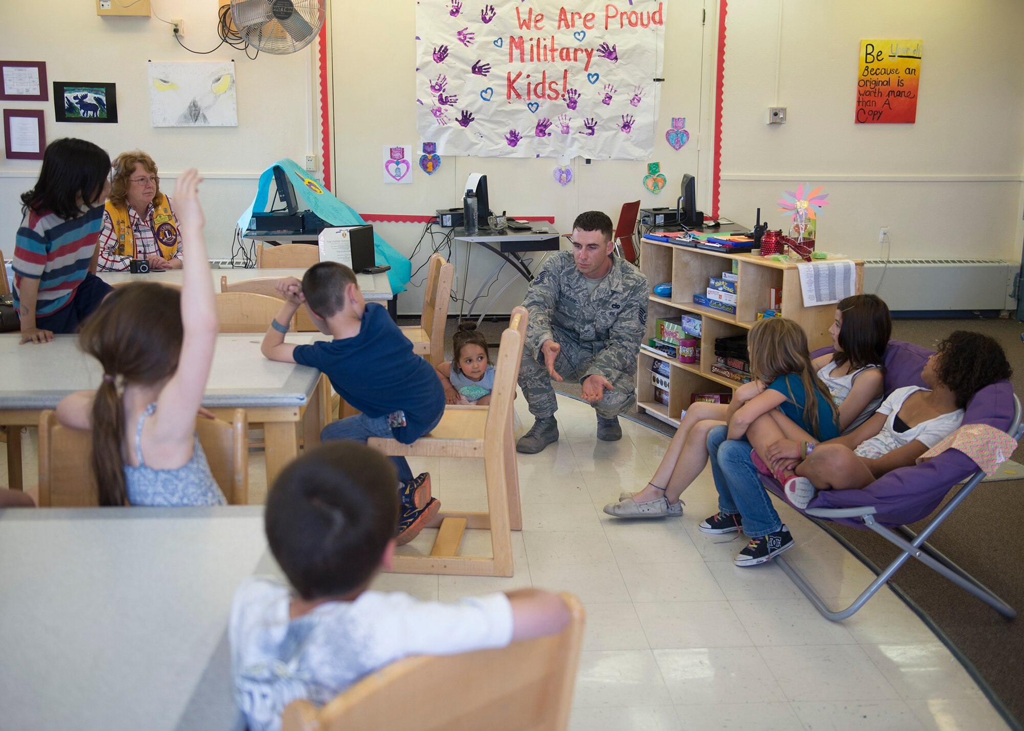 U.S. Air Force Tech. Sgt. Jimmy Boulware, a 354th Logistics Readiness Squadron quality assurance inspector, answers questions at the school age program May 27, 2015, at Eielson Air Force Base, Alaska, about being injured in an improvised explosive device blast while deployed in 2005. Boulware shared his story with the students to help them understand the significance and history of the Purple Heart. (U.S. Air Force photo by Staff Sgt. Shawn Nickel/Released)