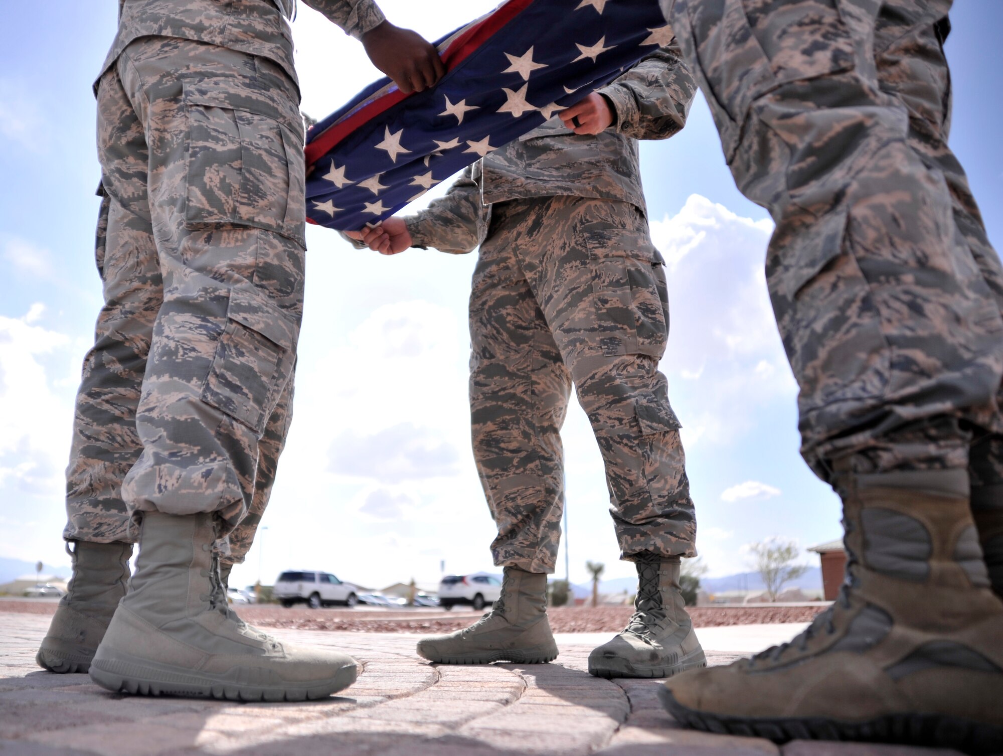 Members of the 799th Security Forces Squadron fold the flag during a retreat ceremony May 14, 2015, at Creech Air Force Base, Nevada. The ceremony took place during National Police Week which honors the fallen law enforcement officers who have paid the ultimate sacrifice. (U.S. Air Force photo by Airman 1st Class Christian Clausen/Released)