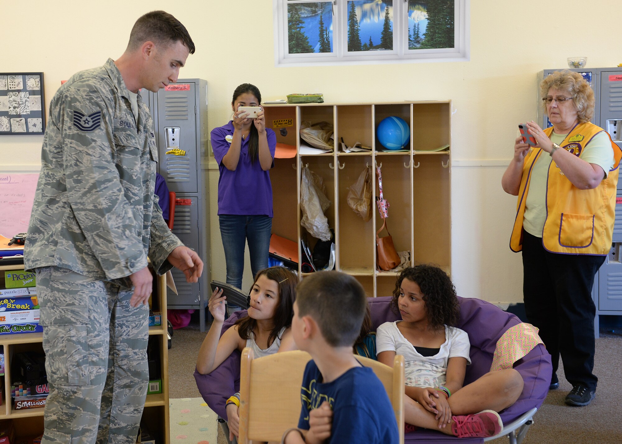 U.S. Air Force Tech. Sgt. Jimmy Boulware, a 354th Logistics Readiness Squadron quality assurance inspector, shows a rifle magazine with a shrapnel hole in it to students during a presentation at the school age program May 27, 2015, on Eielson Air Force Base, Alaska. Boulware, who was injured in an improvised explosive device blast during a deployment in 2005, shared his story with the students to help them understand the significance of the Purple Heart. (U.S. Air Force photo by Staff Sgt. Shawn Nickel/Released)
