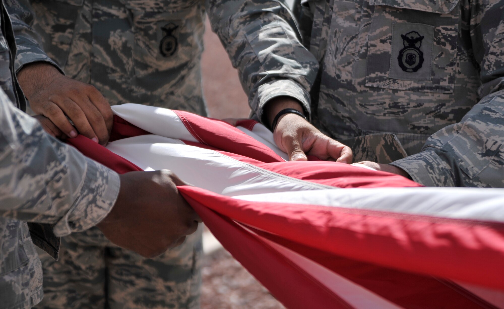 Members of the 799th Security Forces Squadron fold the flag during a retreat ceremony May 14, 2015, at Creech Air Force Base, Nevada. The 799th SFS, local highway patrol officers and the Las Vegas Police Department gathered during National Police Week at Creech AFB for a law enforcement fitness challenge and retreat ceremony. (U.S. Air Force photo by Airman 1st Class Christian Clausen/Released)